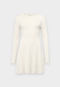 Robe à manches longues en tissu côtelé crème doux. Le corsage ajusté se transforme en une jupe évasée. Encolure ronde, sans accessoires ni motifs visibles.