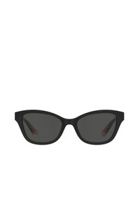 Occhiali da sole cat-eye neri con lenti scure, finitura opaca, montatura angolare, aste sottili e un dettaglio logo discreto sulla parte interna delle aste.