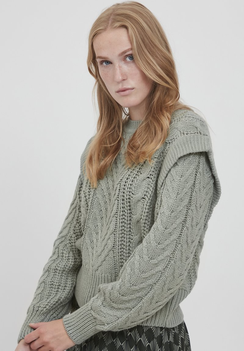 Strickpullover in Hellgrün mit Zopfmuster, gerippten Bündchen und Rundhalsausschnitt. Verfügt über ein strukturiertes Design an den Ärmeln.