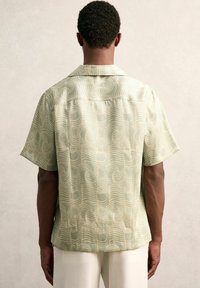 Korte mouwen shirt in lichtgroene stof met een herhalend golfpatroon, subtiele glans, ontspannen pasvorm en een klassieke kraagontwerp.