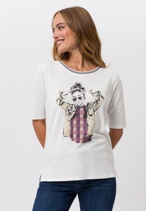 White short-sleeve t-shirt featuring a graphic print of a figure wearing sunglasses, with a purple checkered sweater pattern. Accented neckline.