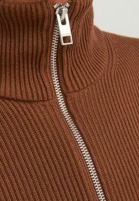 Suéter de cuello alto marrón con canalé que presenta un cierre de cremallera plateada, con tejido de punto texturizado y diseño de cuello alto.