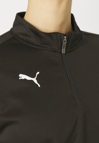 Zwarte hoodie van textuurstof. Beschikt over een hoge kraag, een rits aan de voorkant en een wit Puma-logo op de linker borst.