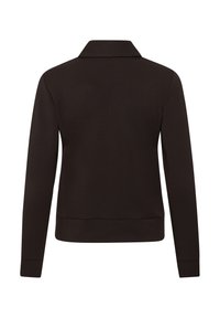 Melna jaka ar garām piedurknēm, augstu apkakli, taisnu apakšmalu un piegulošām aprocēm, attēlota no aizmugures uz balta fona.