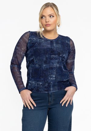 Denim-geïnspireerde top met lange, transparante mouwen in een donkerblauwe tint, met textuurpatronen die doen denken aan zakken en stikdetails.