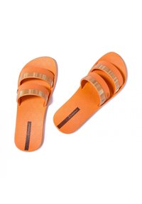 Sandali scivolati arancioni con due accenti di cinture dorate, soletta testurizzata e forma arrotondata. Include il logo del marchio sulla suola.