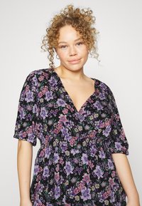 Vestido floral com fundo preto adornado com flores roxas e cor-de-rosa, design em v, mangas curtas e bufantes, e cintura franzida.