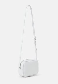 Bolso cruzado de cuero blanco con forma rectangular, cierre de cremallera, correa ajustable y textura suave.