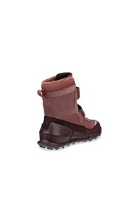 Stivale impermeabile color bordeaux con collo alto, pannelli testurizzati e suola in gomma. Presenta cinturini regolabili e un tallone rinforzato.