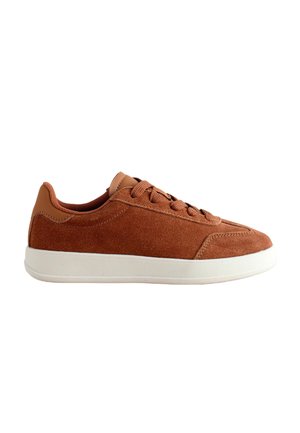 Brune ruskind sneakers med hvid gummisål, rund tå, snørebåndslukning og tonale accenter på hælen og tungen.