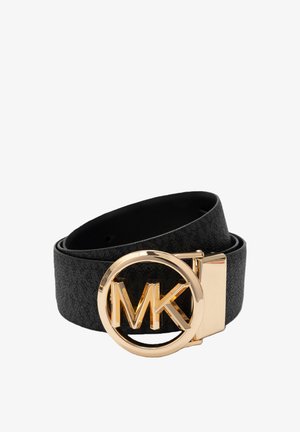 Zwarte leren riem met grote ronde gouden gesp met gestileerde "MK" initialen in het midden, opgerold tegen een witte achtergrond.