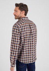 Camicia a quadri marrone e blu con maniche lunghe, polsini con bottone e colletto a punta. Realizzata in cotone con una texture morbida e una vestibilità casual.