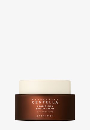 Braunes Glas mit weißem Deckel, beschriftet mit "Madagascar Centella Probio-Cica Enrich Cream", Inhalt 15 ml. Glatte Textur, kompaktes Design.