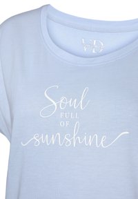 Vaaleansininen puuvillainen t-paita lyhyillä hihoilla, jossa edessä on valkoinen script-teksti, joka sanoo "Soul Full of Sunshine".