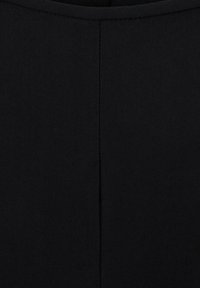 Gros plan d'un tissu noir avec une couture verticale centrée et un détail de couture incurvée en haut.