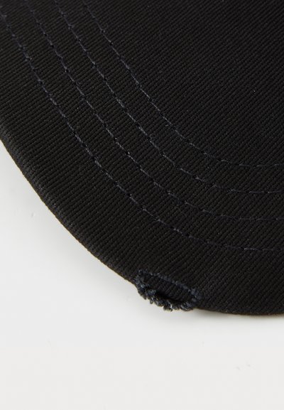 Casquette noire avec un visière incurvée, fabriquée en tissu texturé. Présente des coutures visibles et un petit trou sur le côté.