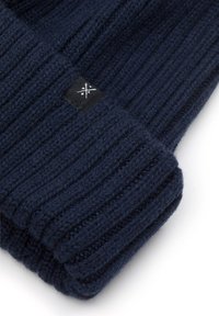 Granatowa dziana czapka z prążkowanym wzorem, z małą czarną metką z logo. Ciepły materiał, złożony design z mankietem dla regulowanego dopasowania.
