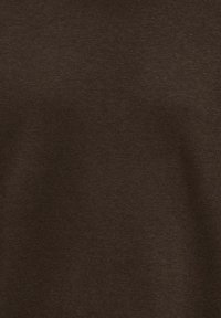 Gros plan sur la texture d’un tissu marron montrant un motif de tricot fin et une surface de matériau douce.