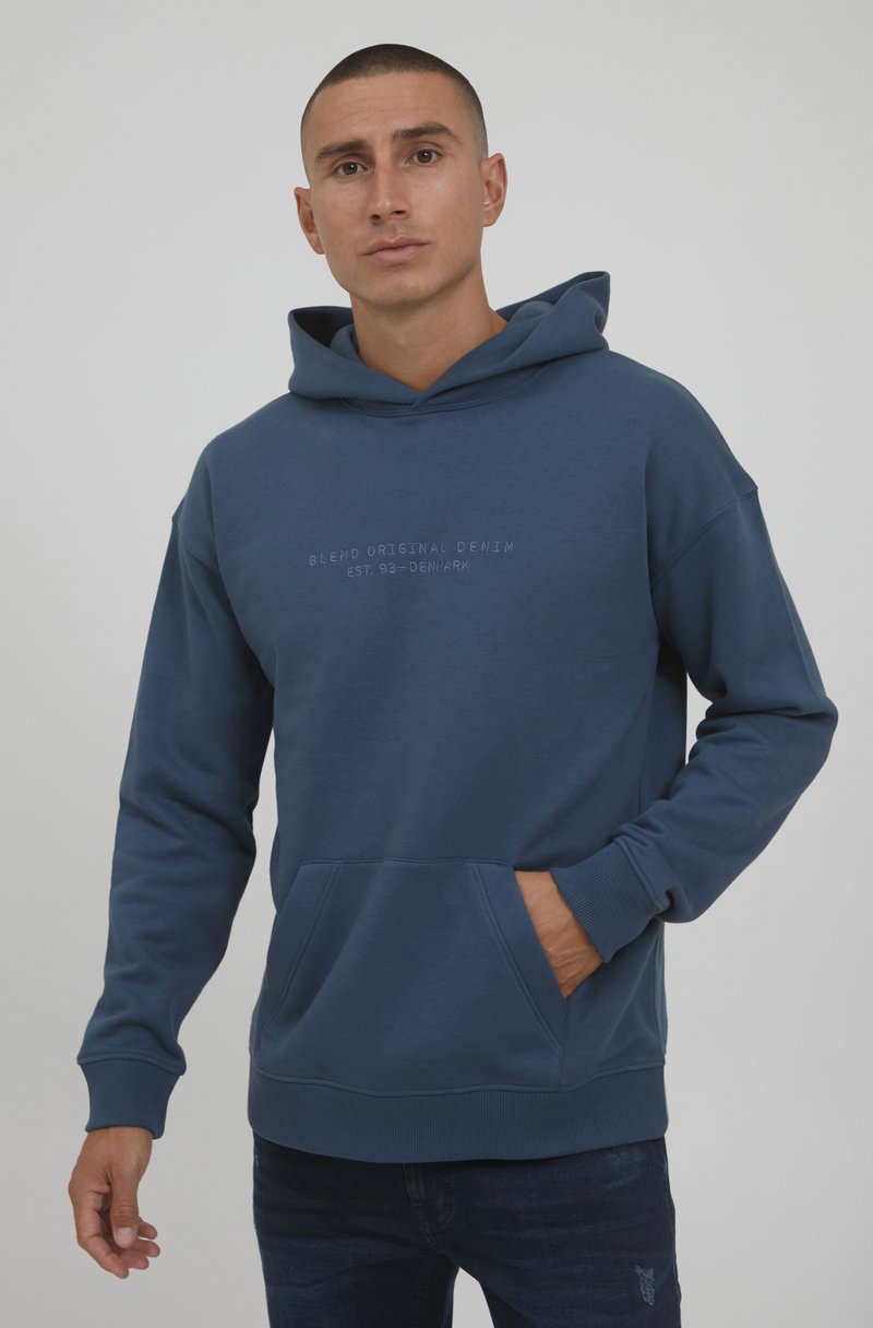 Blauer Kapuzenpullover mit einer Taschenfront, aus weichem Material, mit lässiger Passform und geprägtem Textdesign. Ribbelbündchen und Saum.