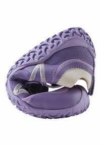 Chaussure de sport flexible violette pliée pour montrer sa semelle souple et sa tige en tissu respirant.