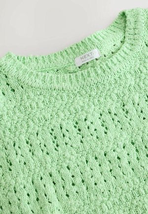 Mintgrön stickad tröja med ett texturerat mönster med små hål och bumpor, rund halsringning, och etikett sydd inuti.