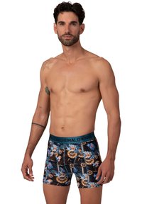 Férfi boxer alsónadrág, testhez álló szabással, kék virágos és dekoratív mintával. A derékpánt sötétkék, "Muchachomalo" márkázással.