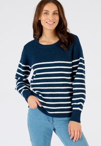 Suéter azul marino con rayas blancas, parte superior texturizada, cuello redondo y mangas largas, combinado con jeans azul claro.