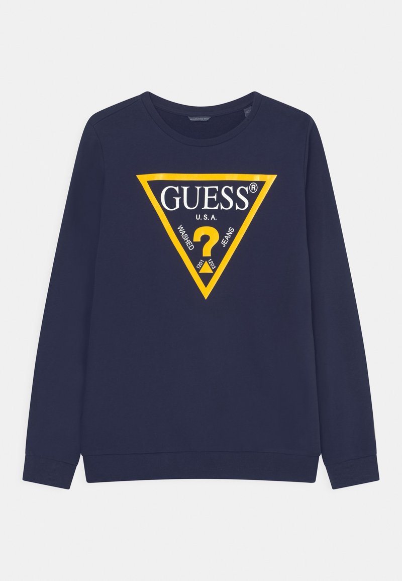 Sweat-shirt bleu marine à manches longues avec un logo triangulaire jaune indiquant "GUESS U.S.A." avec un point d'interrogation et les mots "washed jeans."