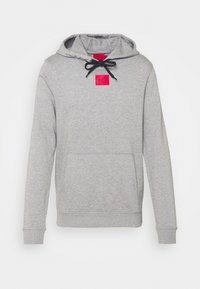 Sudadera gris hecha de algodón suave, con un bolsillo frontal, capucha con cordón y un parche de marca rosa en el pecho. Puños y dobladillo acanalados.