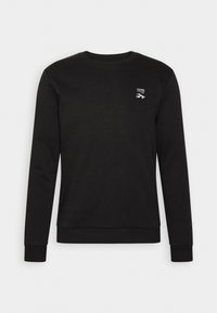 Sweat-shirt noir à col rond avec manches longues et petit logo blanc "CORE" sur le haut gauche de la poitrine.