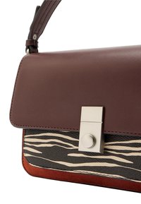 Brązowa skórzana torebka z teksturowanym czarno-kremowym wzorem zebry, wyposażona w srebrną klamrę i pomarańczowy zamszowy akcent na spodzie.