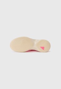 Shoe sole in light beige rubber with textured patterns, featuring a pink accent on the heel. Smooth, durable material with a rounded shape.