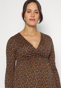 Vestido preto de flores de manga longa com um decote em V profundo, apresentando padrões de flores laranja e roxas e um detalhe de cintura franzida.