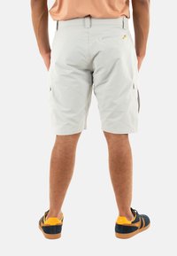 Pantaloni cargo grigi chiari in tessuto leggero con tasche laterali, una tasca con zip sul retro e una vita aderente.