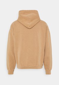 Hooded sweatshirt in a tan color with a soft texture, featuring dropped shoulders and a relaxed fit, no visible logos or patterns.