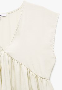 Abito beige chiaro con scollatura a V, maniche corte, vita arricciata e una texture morbida e liscia. Design semplice e privo di ornamenti.