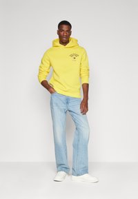Tommy Hilfiger ARCHED VARSITY HOODY - Sportinis megztinis - eureka yellow