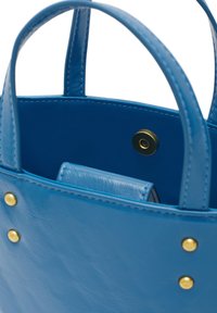 Borsa a mano in pelle blu con una consistenza liscia, due manici corti, dettagli in metallo dorato e chiusura a scatto interna.