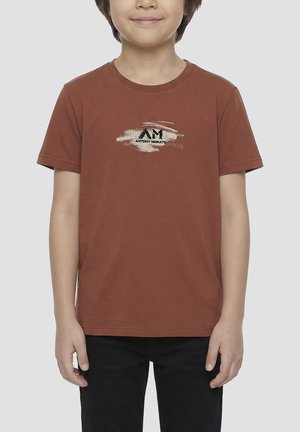 Bambino che indossa una maglietta marrone a maniche corte con una pennellata bianca e il logo nero "Antony Morato", abbinata a pantaloni neri.