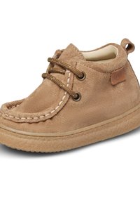 Stivaletti per bambini in suede tan con due fori per i lacci, cuciture bianche a contrasto, suola in gomma e una patch in pelle sul lato.