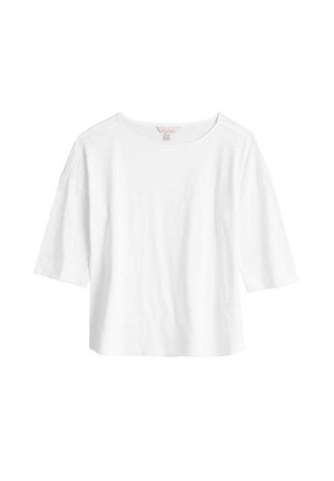 Biała koszula z krótkim rękawem o szerokim dekolcie, luźny krój i miękka tekstura. Prosty design, bez ozdób i wzorów.