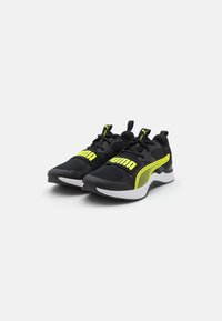 Pantofi sport negri cu accente galbene. Fabricati din material din plasă și cu tălpi din cauciuc. Au o suprafață texturată și un logo proeminent pe lateral.