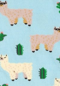 Lichtblauwe stof met herhaalde patronen van crèmekleurige en roze lama's en groene cactussen in een cartoonstijl.