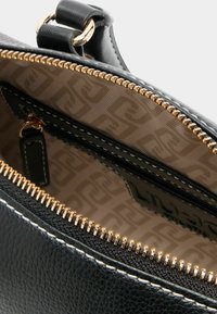 Schwarze Lederhandtasche mit Innenfutter und goldenen Reißverschluss sowie kontrastierenden weißen Nähten. Gefüttert mit einem gemusterten beige Stoff.