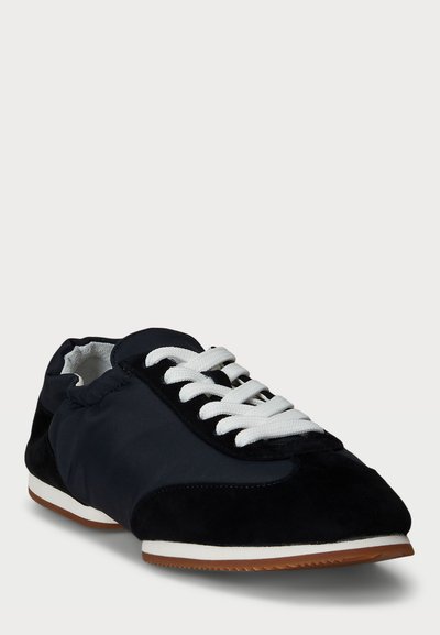Sneakers blu navy con una combinazione di suede liscio e testurizzato, lacci bianchi e suola in gomma. Punta arrotondata, design a taglio basso e accenti minimalisti.