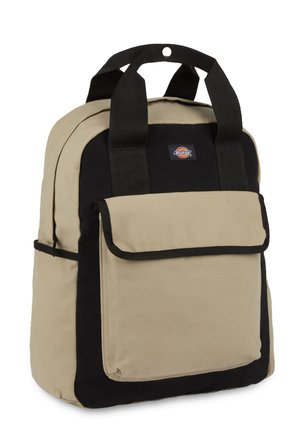 Mochila de lona en beige y negro, con asas acolchadas, un bolsillo frontal con solapa y un fondo reforzado para mayor durabilidad.