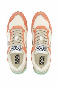 Baskets avec une tige en mesh crème, des accents en daim orange, des lacets beiges, une semelle verte et une étiquette logo à carreaux sur la languette.