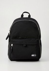 Schwarzer Rucksack mit strukturierter Oberfläche, doppeltem Reißverschluss, Fronttasche und Logopatch. Verfügt über einen abgerundeten oberen Teil und robuste Schultergurte.