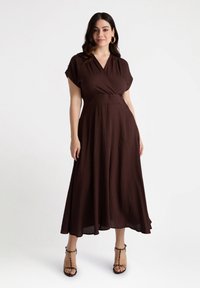 Braunes Wickelkleid aus leichtem Stoff, mit kurzen Ärmeln, einer taillierten Taille und einem fließenden Rock, der bis zur Mitte der Waden reicht.