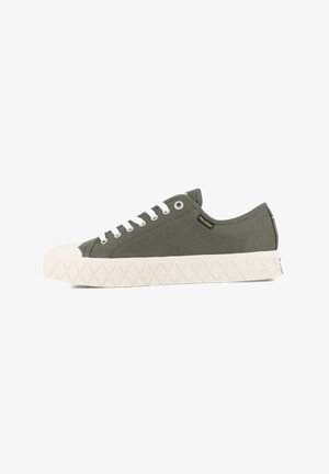 Olive canvas sneakers with a white rubber toe cap and textured, white outsole. Five eyelet lace-up design with a yellow tag detail.